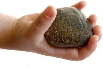 Child's Hand Holding Up a Rock
